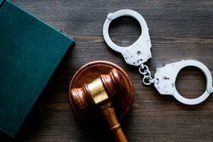 handcuffs with gavel and book on desk