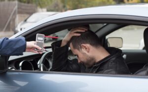 Devastated driver after a crash, subjected to a breathalyzer test for alcohol—highlighting the consequences of drinking and driving.