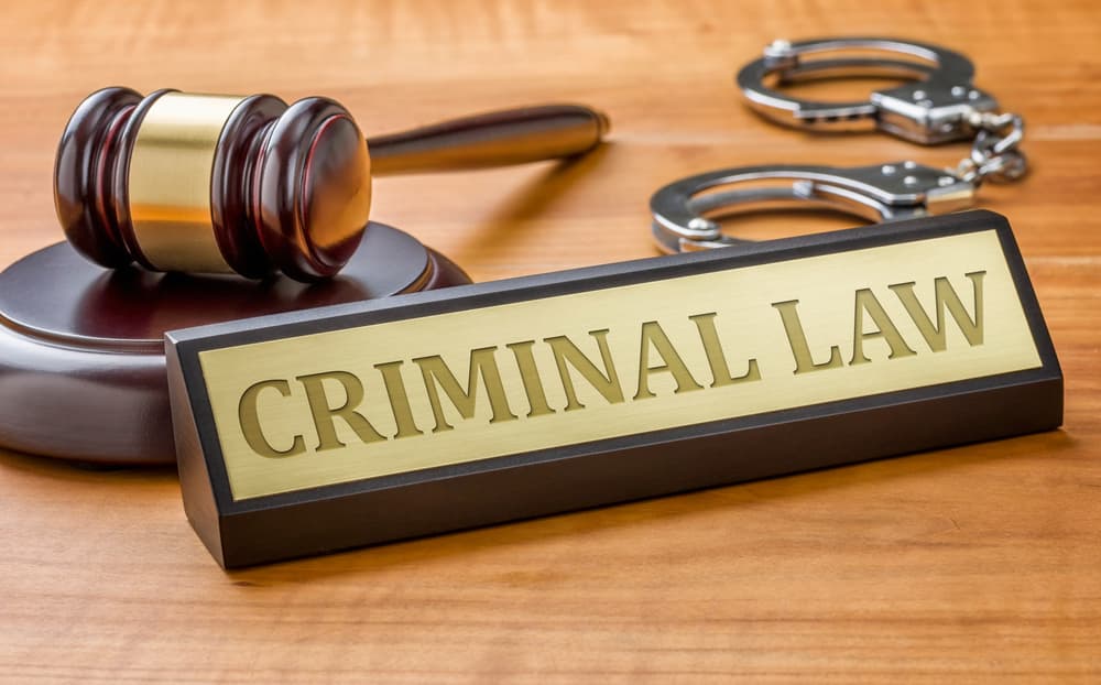 A judge's gavel beside a nameplate engraved with 'Criminal Law'—symbolizing justice, legal authority, and the criminal justice system.